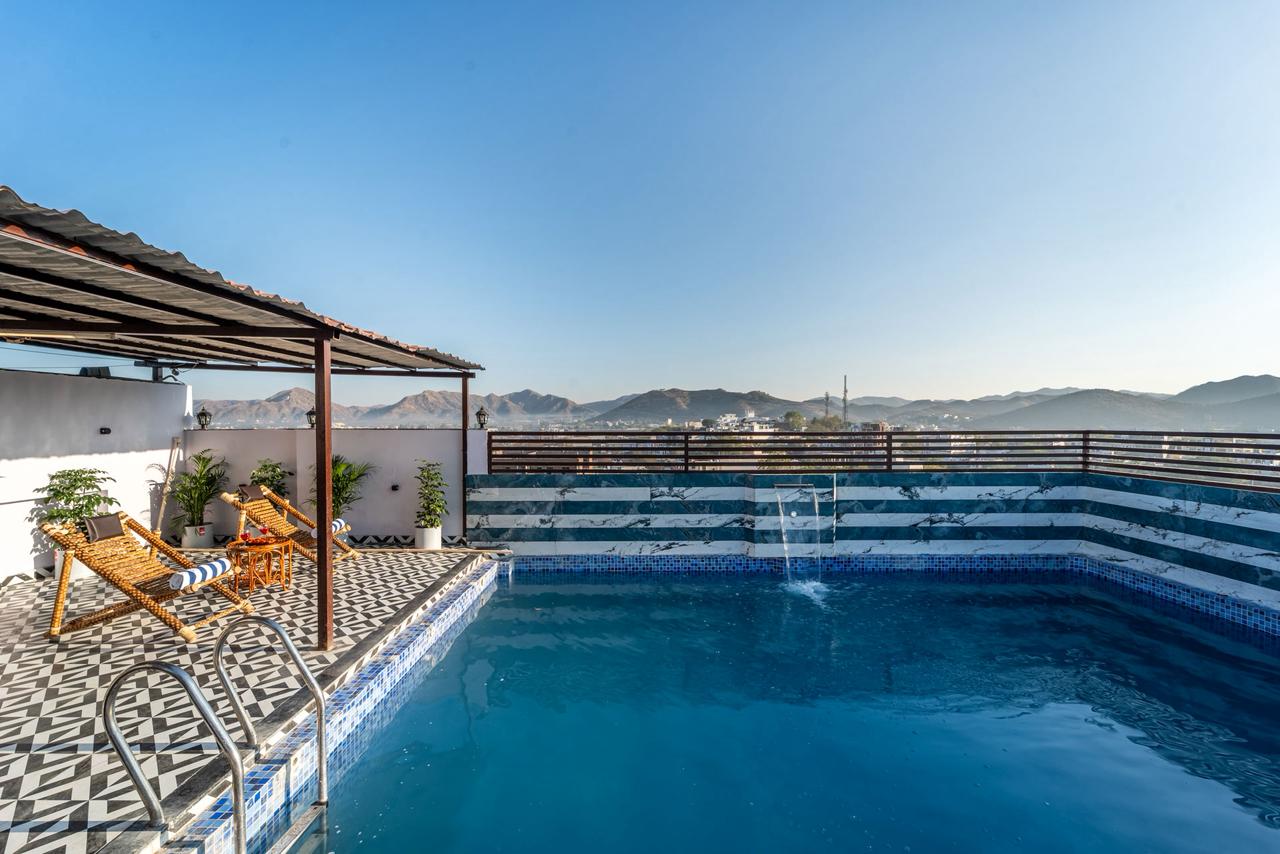 Rooftop pool under a clear blue sky with mountain views
